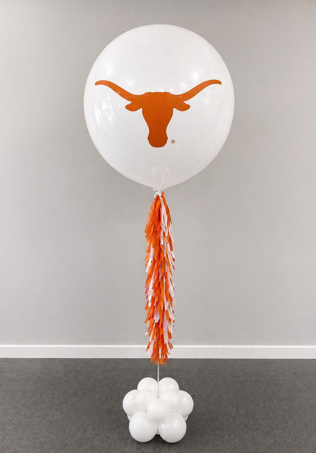 A jumbo helium balloon personalized with University of Texas logo and color, with matching colored tassels..