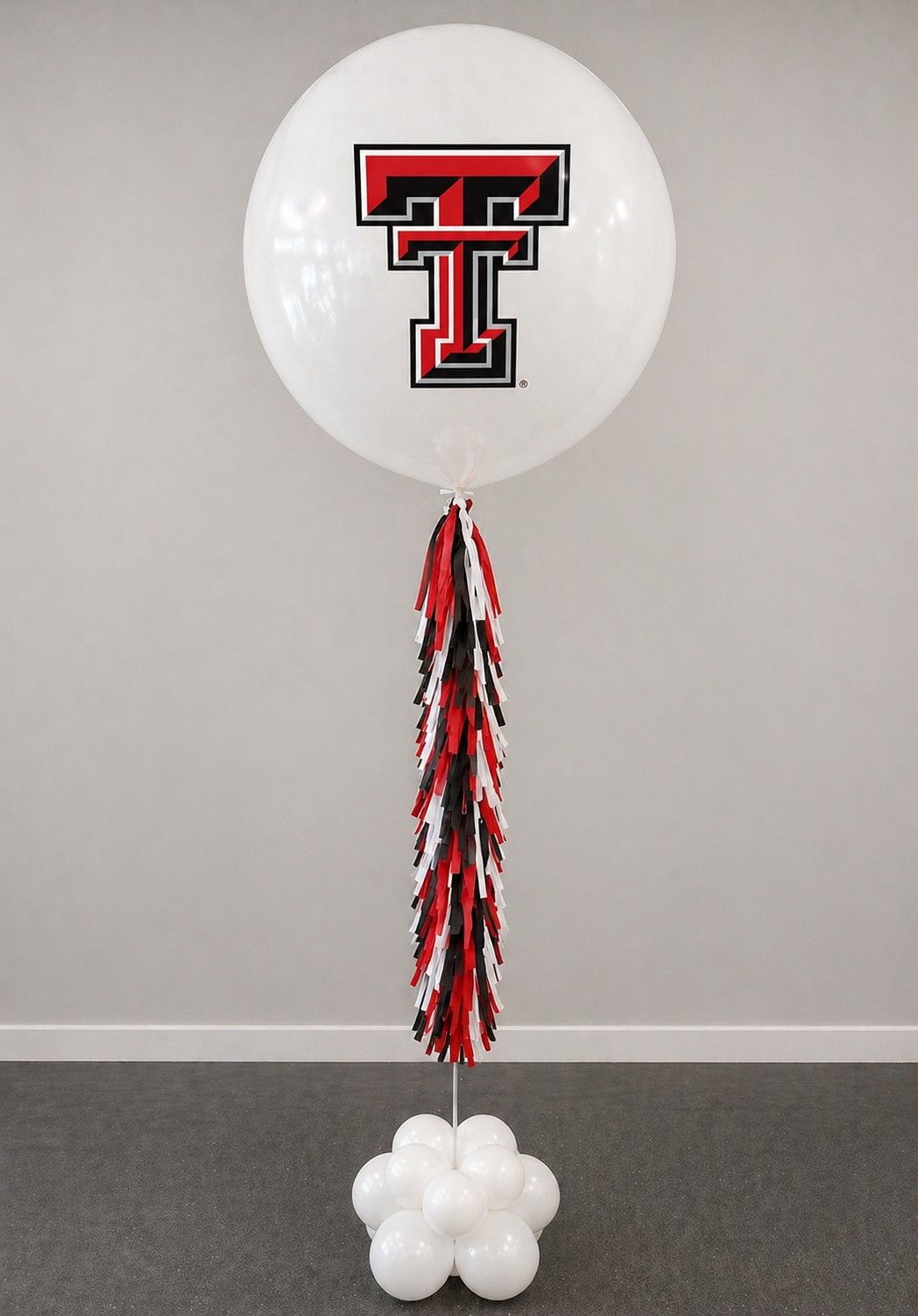 A jumbo helium balloon personalized with Texas Tech College logo and color, with matching colored tassels..