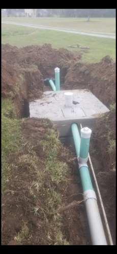 A septic tank is being installed in a hole in the ground.