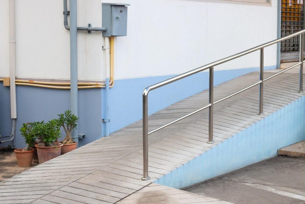 A Ramp With a Stainless Steel Railing is Outside of a Building — Kymar Steel Fabrications in Newcastle, NSW