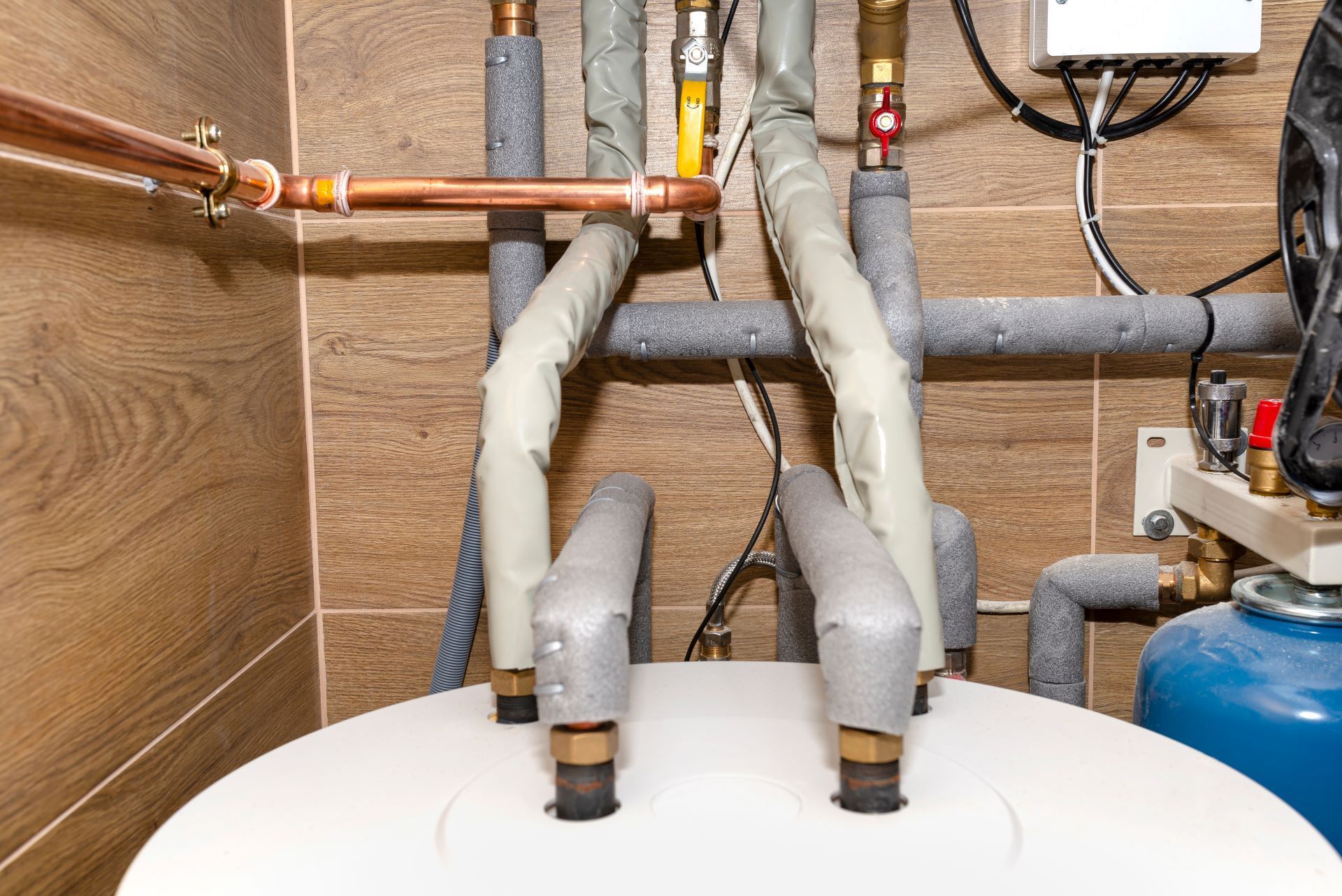 a close up of a water heater in a room with pipes .