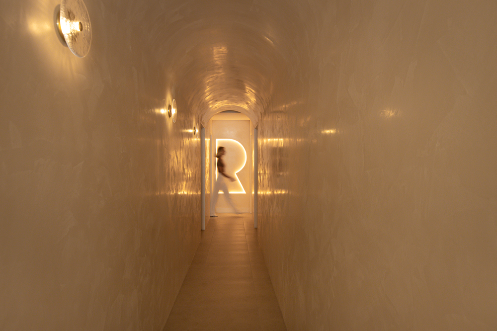 A Person Is Walking Down a Long Hallway with A Light on The Wall — Rejuved in Bateau Bay, NSW