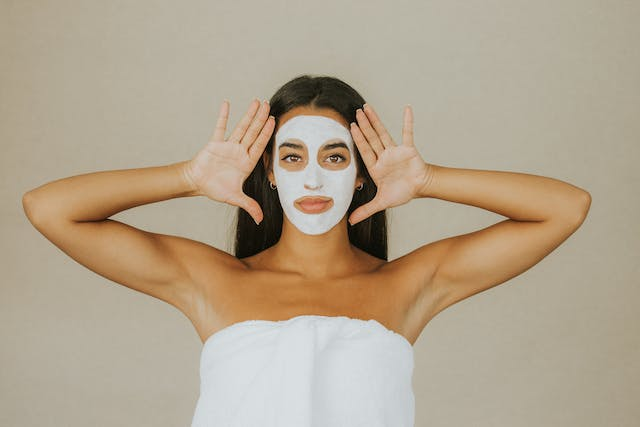 A Woman Is Wrapped in A Towel and Has a White Mask on Her Face — Rejuved in Bateau Bay, NSW