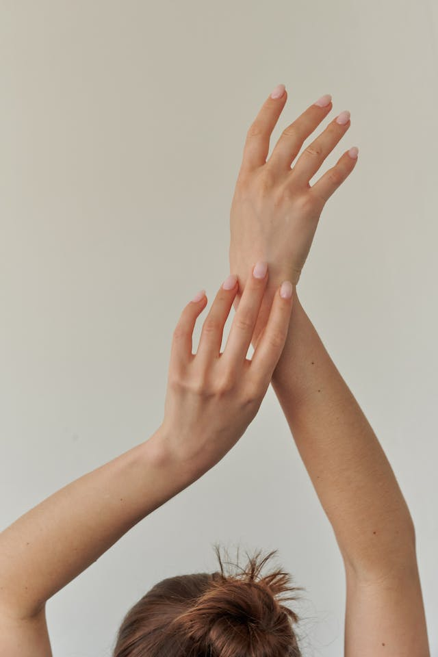 A Woman Is Holding Her Hands up In the Air — Rejuved in Bateau Bay, NSW