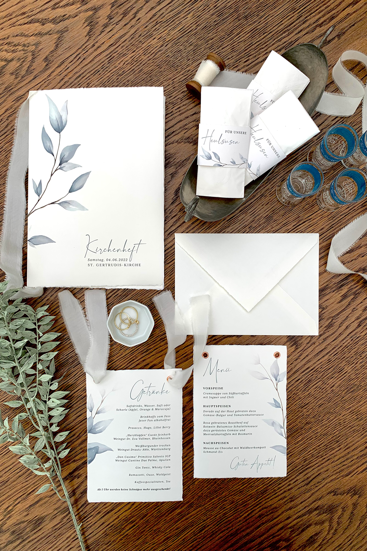 Flatlay Hochzeitspapeterie, Blätterranken auf zartem Büttenpapier, Kirchenheft Hochzeit, Menükarte Hochzeit, Banderolen für Taschentücher