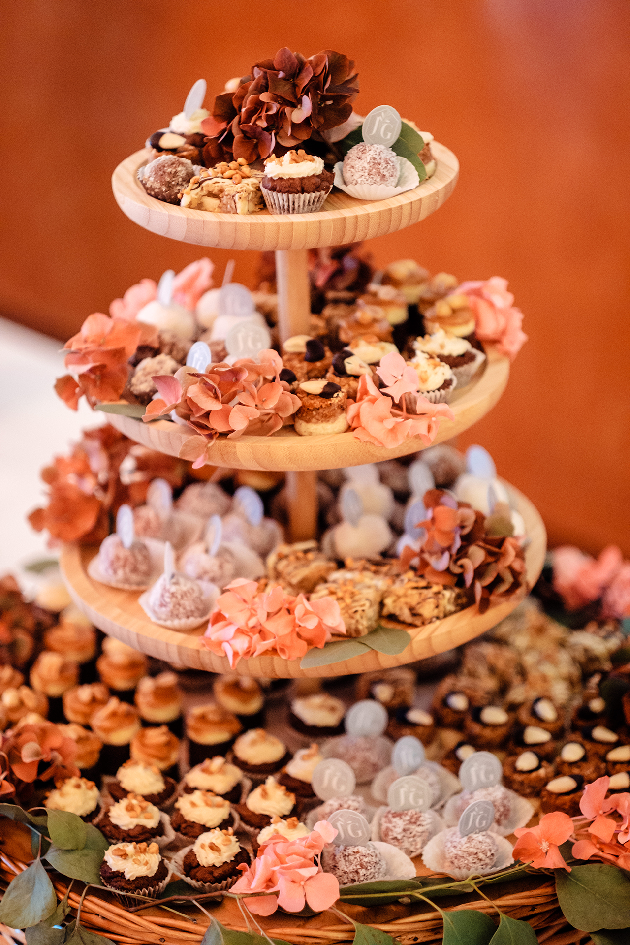 Hochzeitstorte, Konfekt auf Etagere, dekoriert mit Oblaten, auf denen ein Hochzeitslogo gedruckt ist