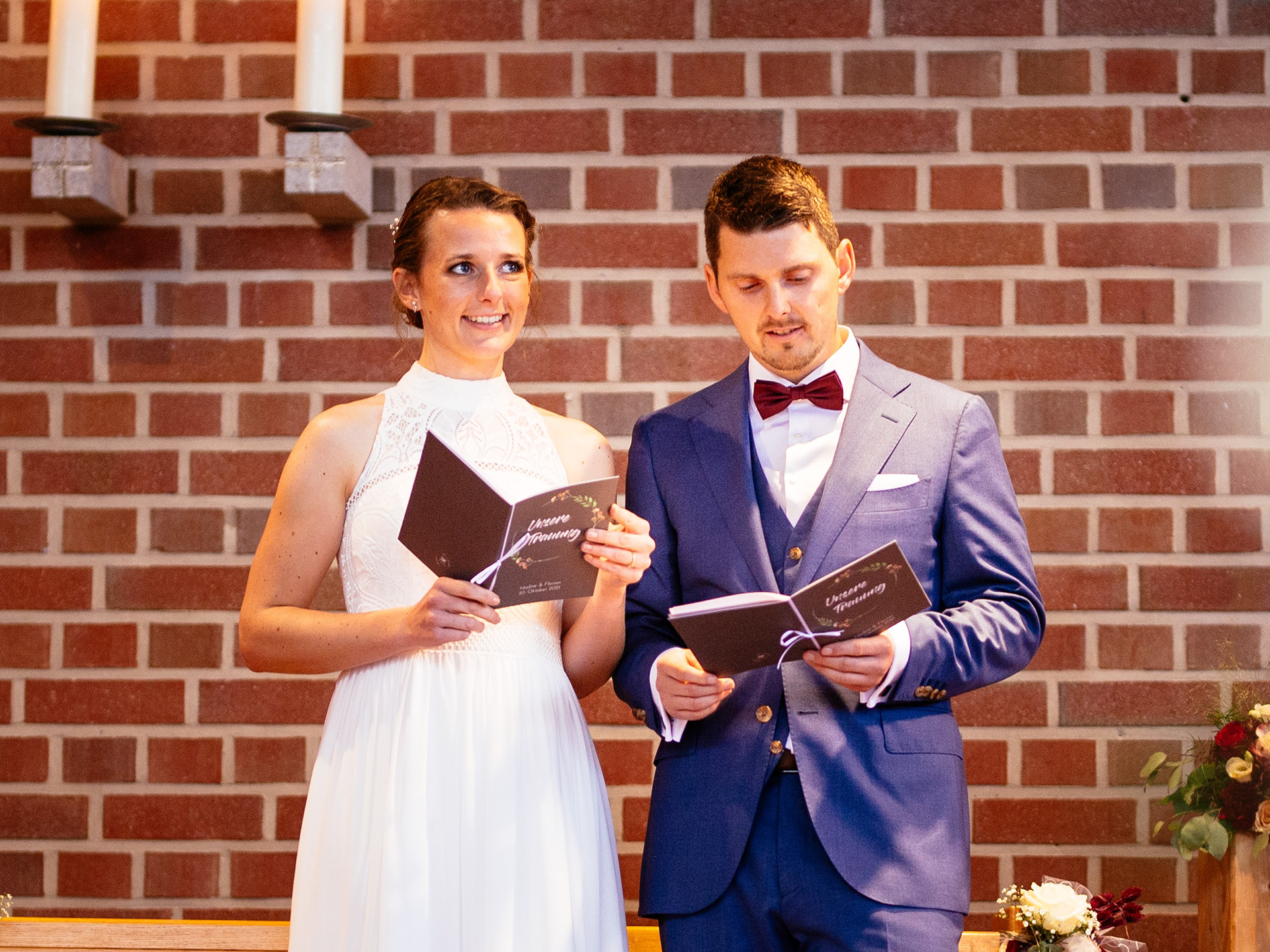 Brautpaar in der Kirche mit Kirchenheft in der Hand