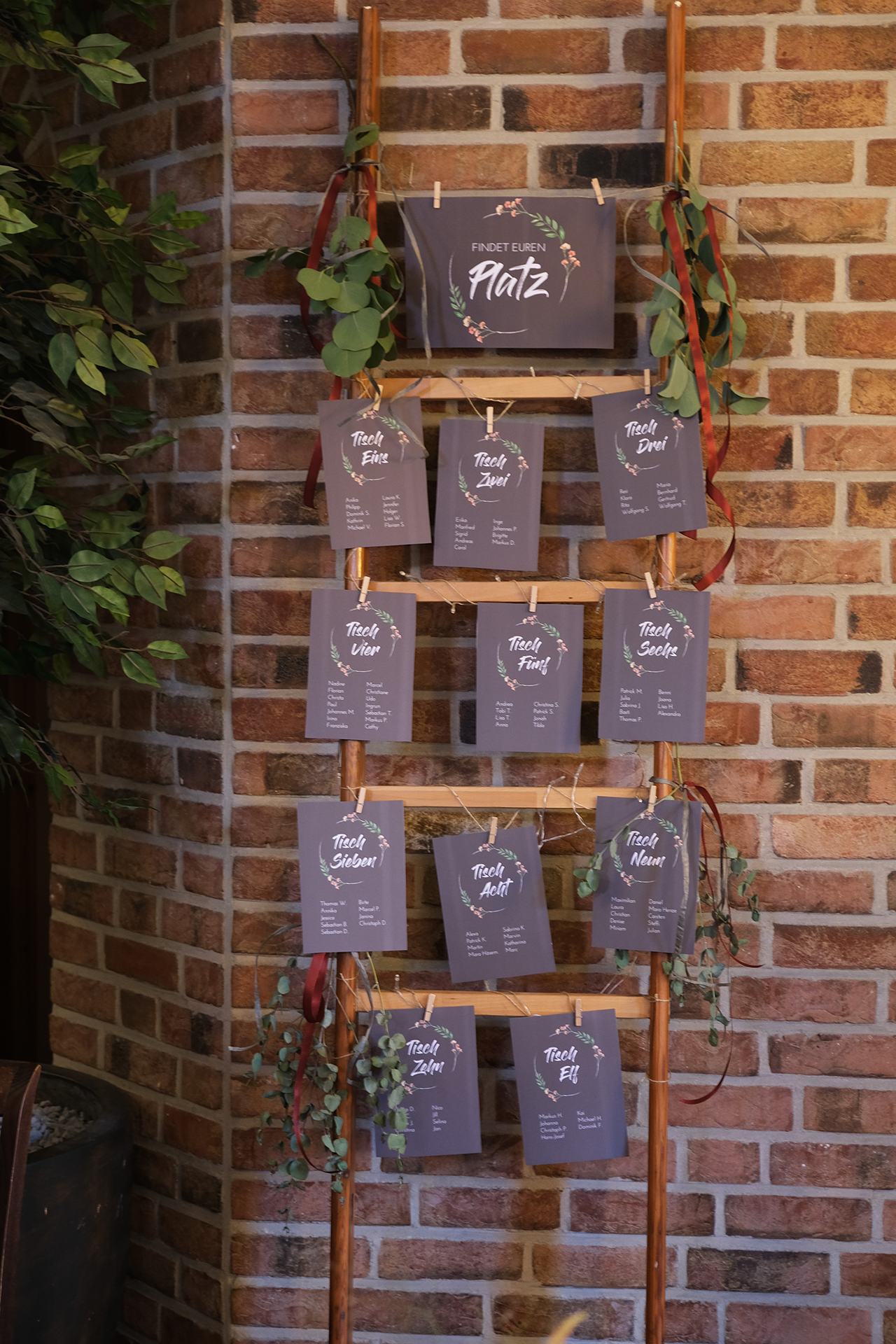 Sitzordnung Hochzeit, Karten mit Sitzordnung an Leiter aufgehängt