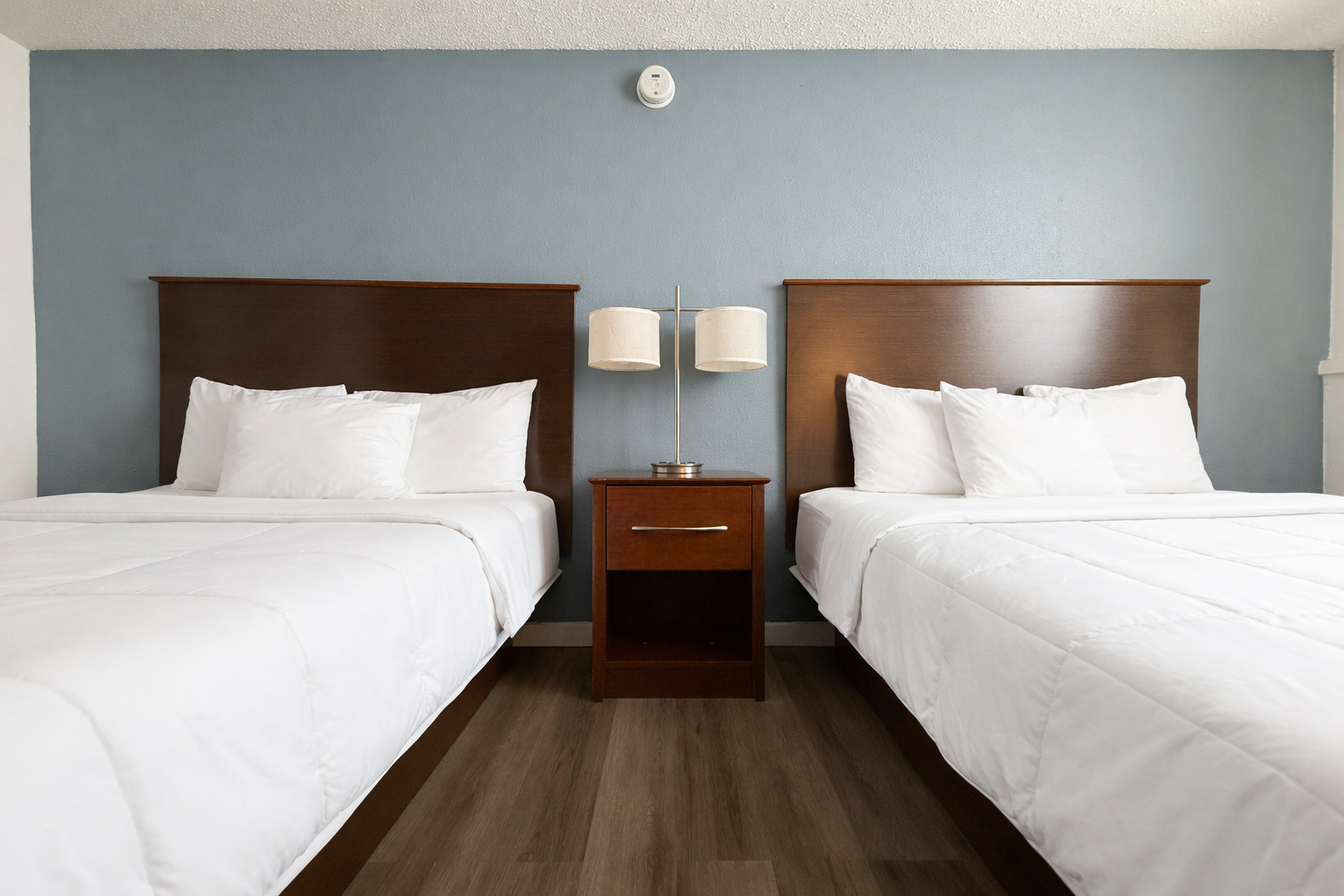 Yellow canoe on shore of calm lake, surrounded by trees and a bright blue sky.