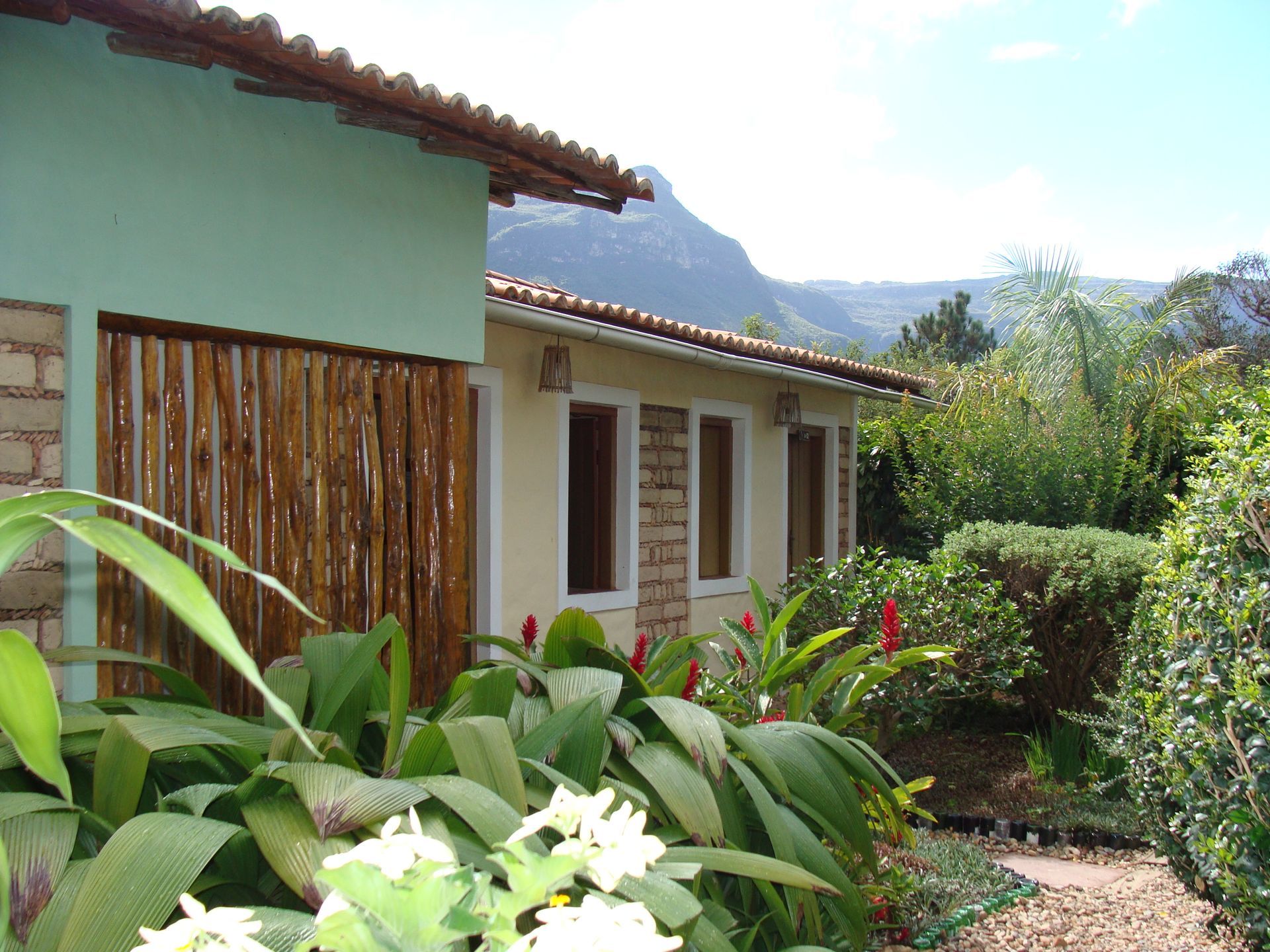 Uma casa com uma cerca de madeira e flores na frente