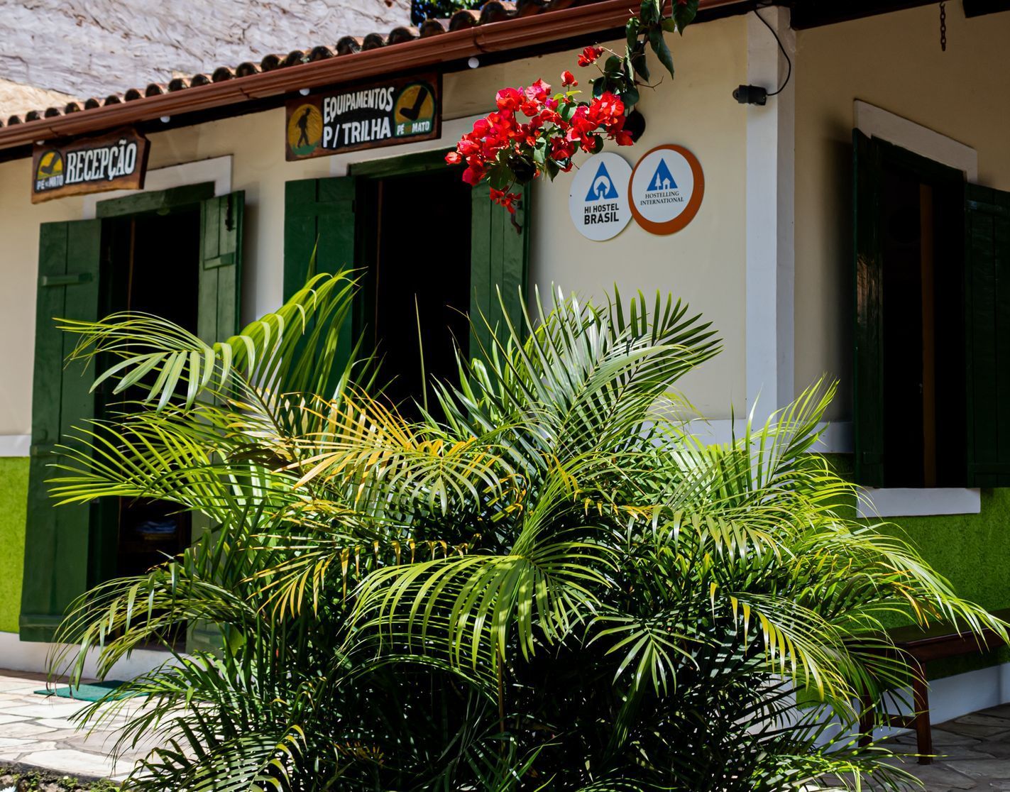 Há uma mesa e cadeiras na varanda de uma casa de madeira.
