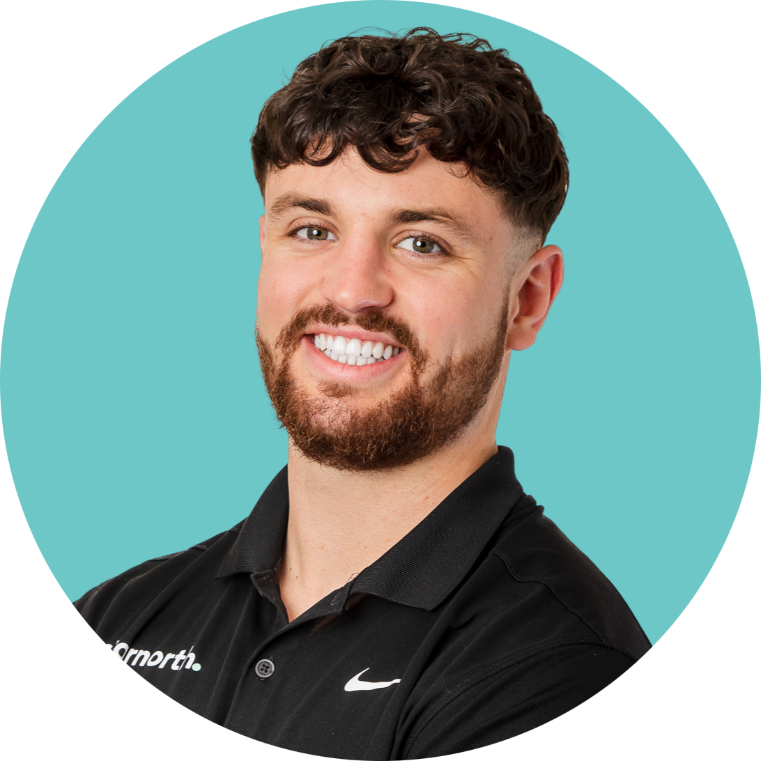 A man with a beard is wearing a black nike polo shirt and smiling.