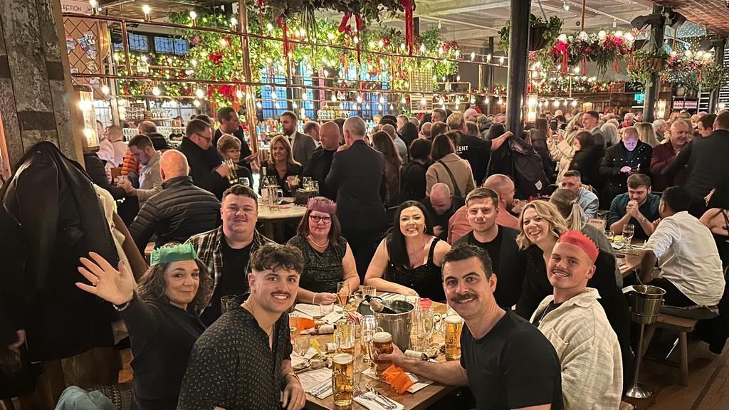 A large group of people are sitting at tables in a restaurant.