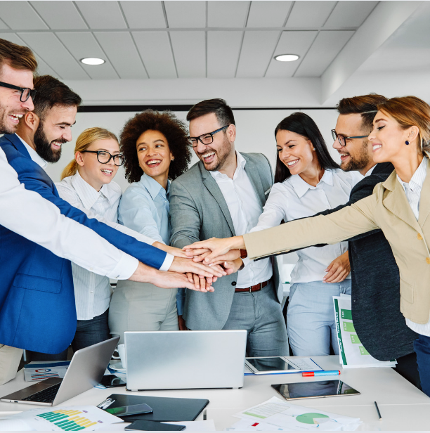 A group of people putting their hands together in an office