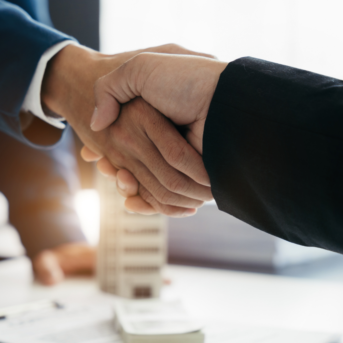 A man in a suit is shaking hands with another man in a suit.