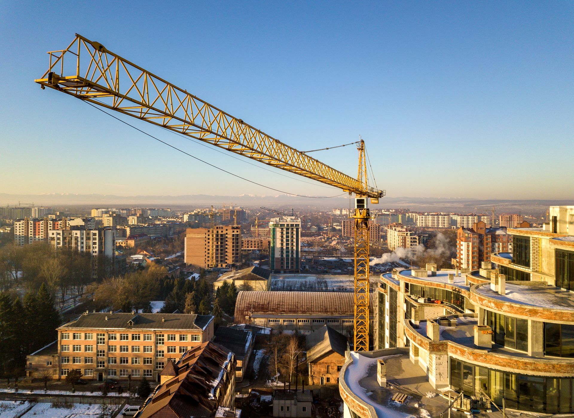 Two construction workers are standing on top of a bridge.