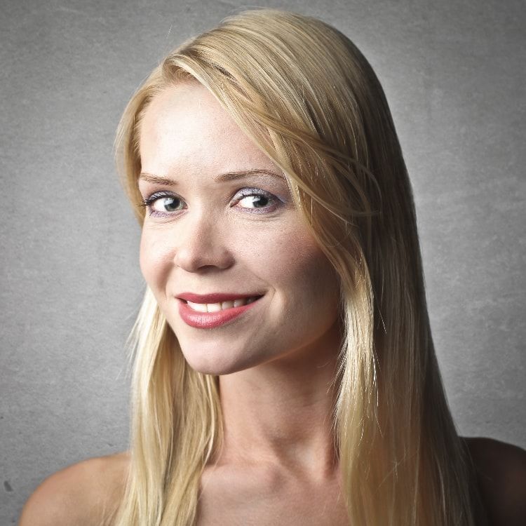 A woman with long blonde hair is smiling for the camera