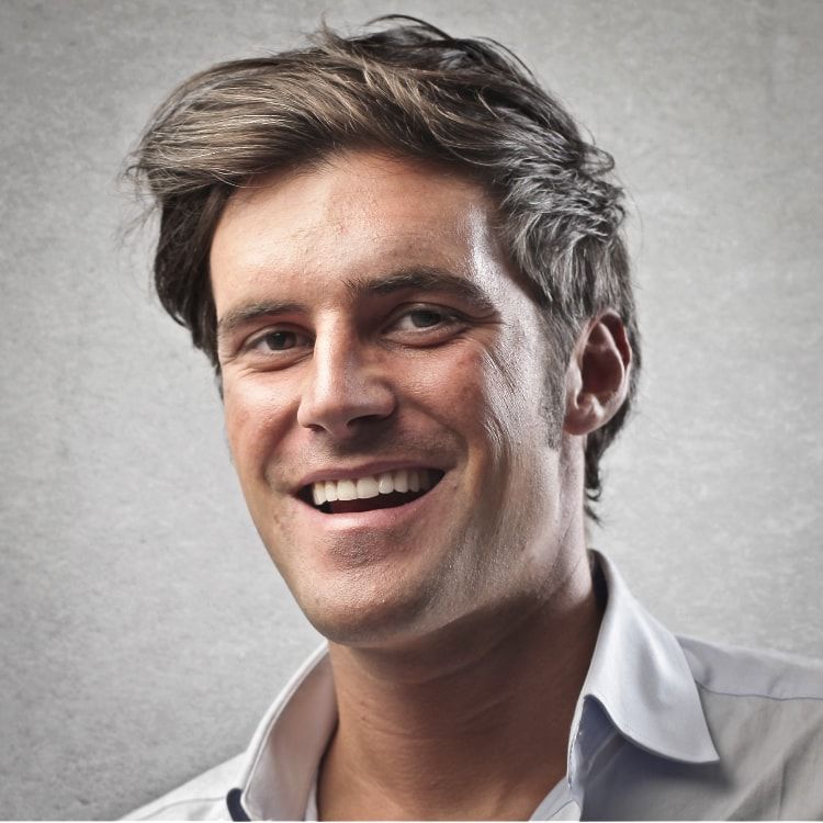 A man in a white shirt is smiling for the camera