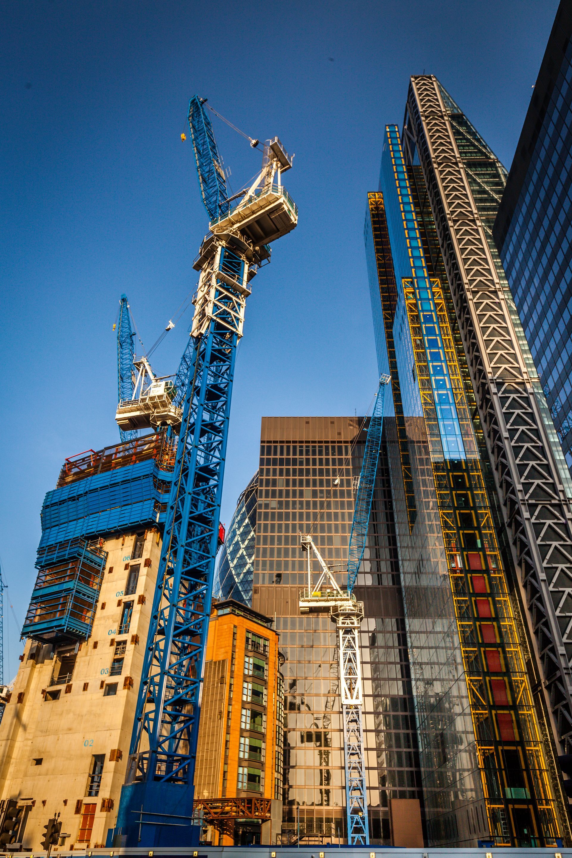 A construction site with a lot of cranes and buildings under construction.
