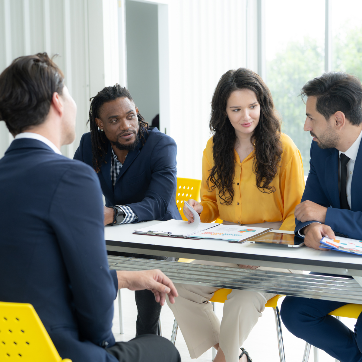 A group of people are sitting around a table having a meeting