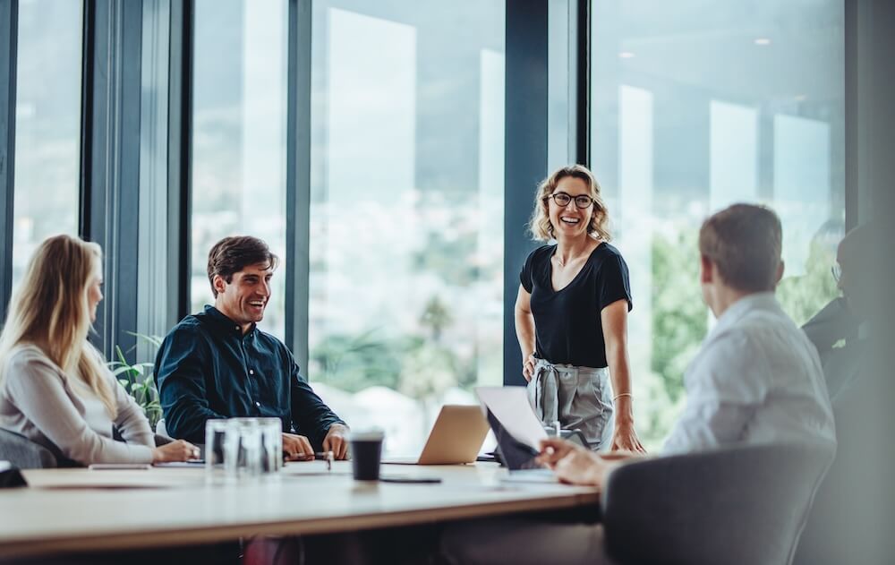 A group of people are sitting around a conference table having a meeting.