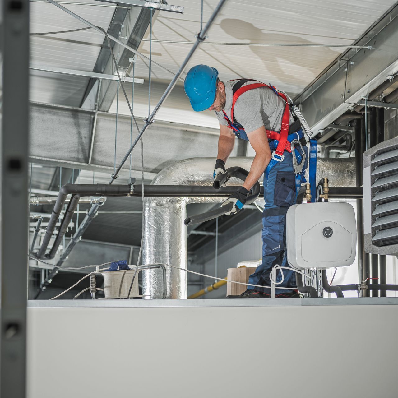 A man is working on a pipe in a building.