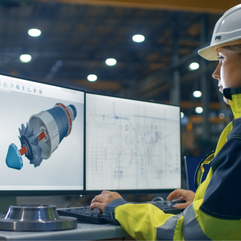 A man wearing a hard hat is working on a computer