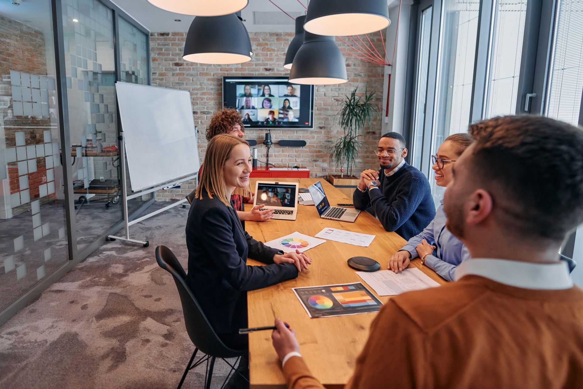 A group of people are sitting around a conference table having a meeting.