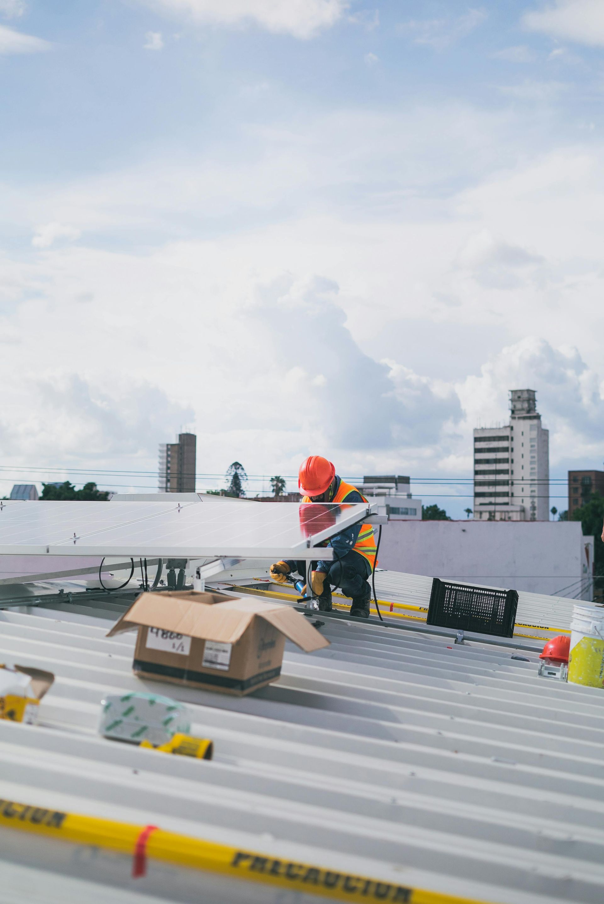 A construction worker is working on the roof of a building.