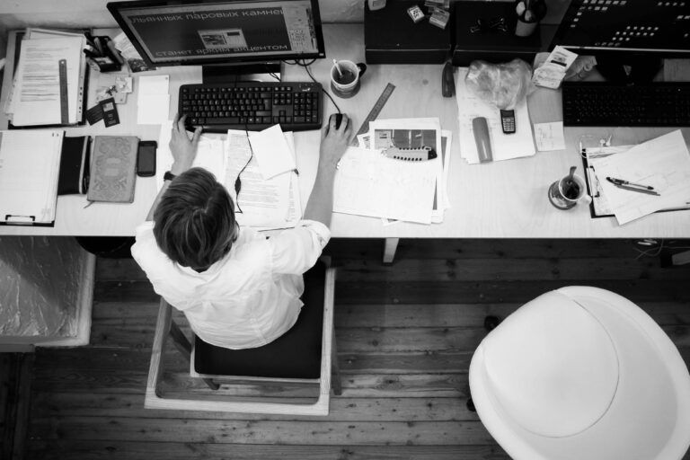 A man is sitting at a desk using a computer