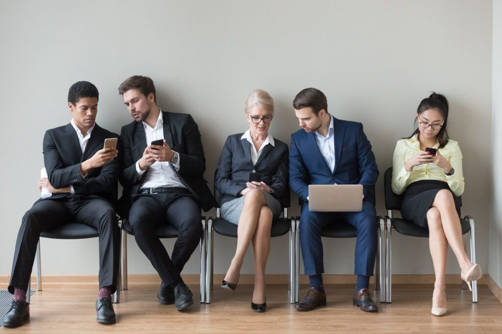 A group of people are sitting in chairs in a waiting room.