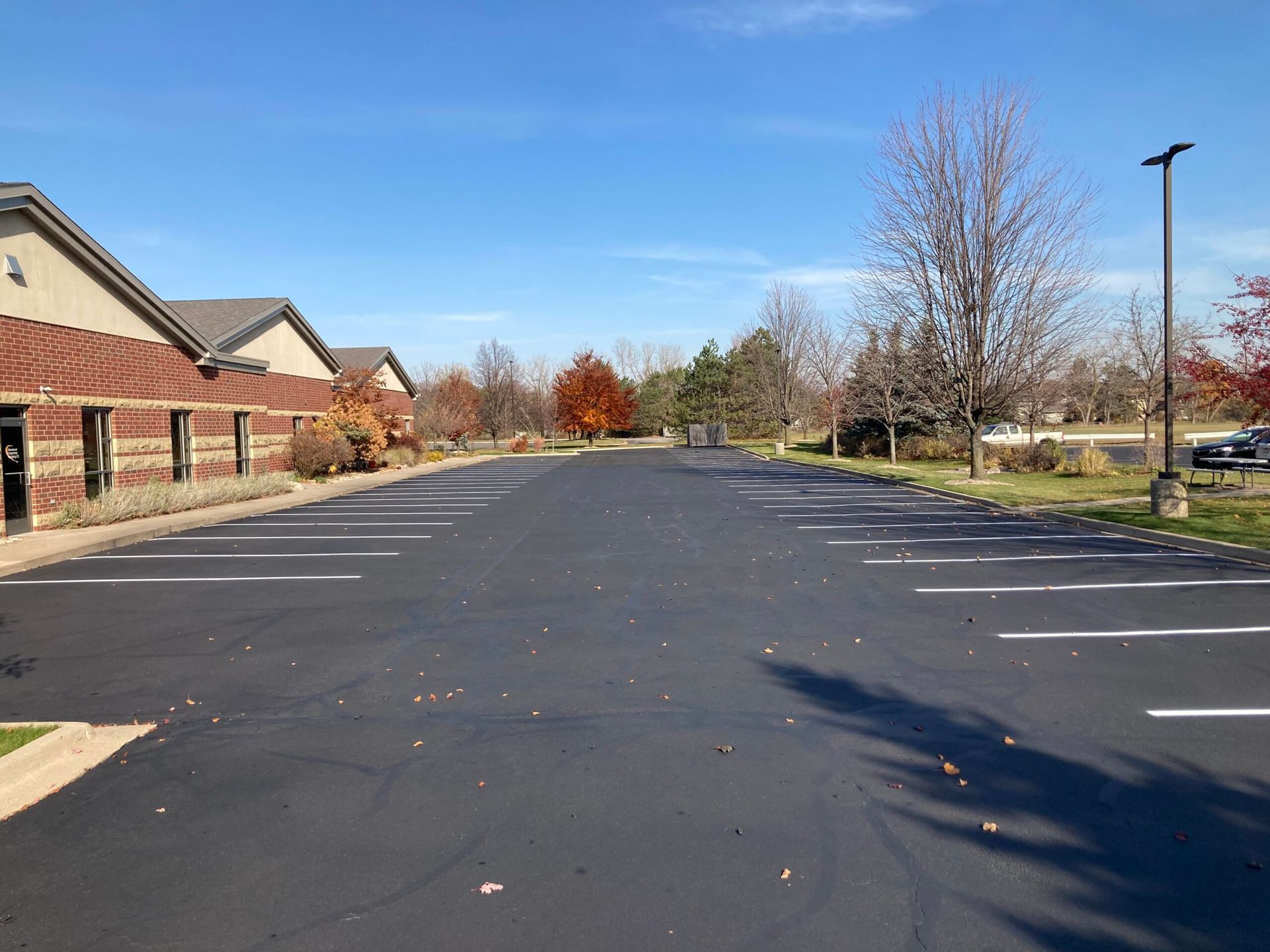 A parking lot with a brick building in the background