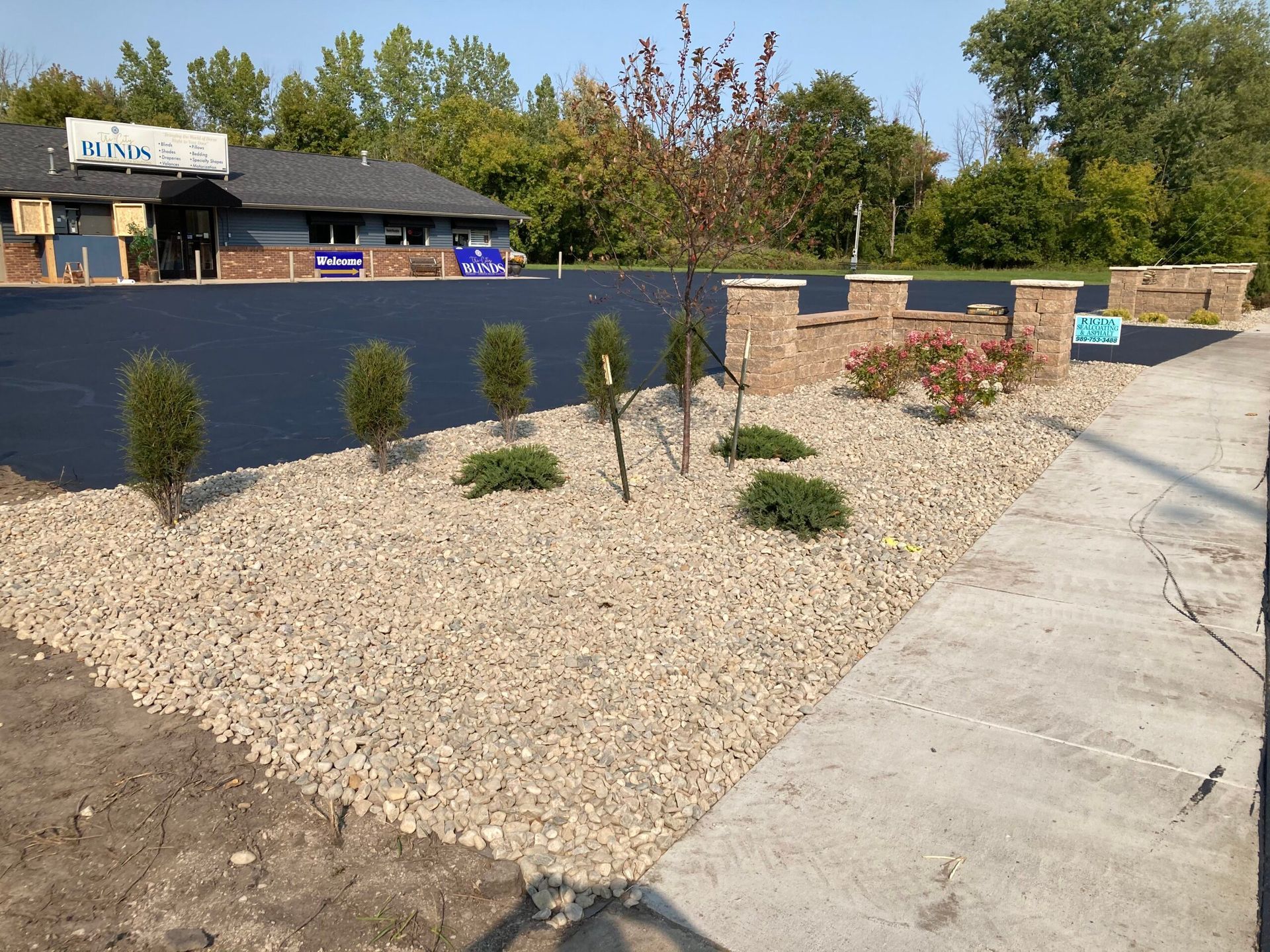 A driveway with gravel and trees in front of a building