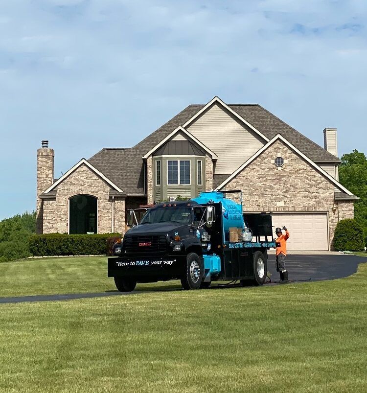 A truck is parked in front of a large brick house