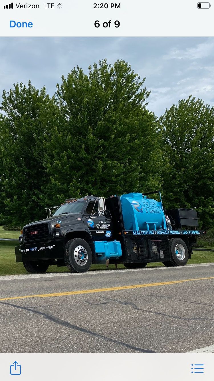 A black and blue truck is parked on the side of the road.