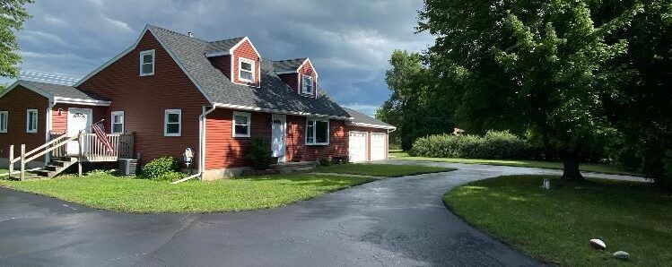 A large red house with a driveway leading to it