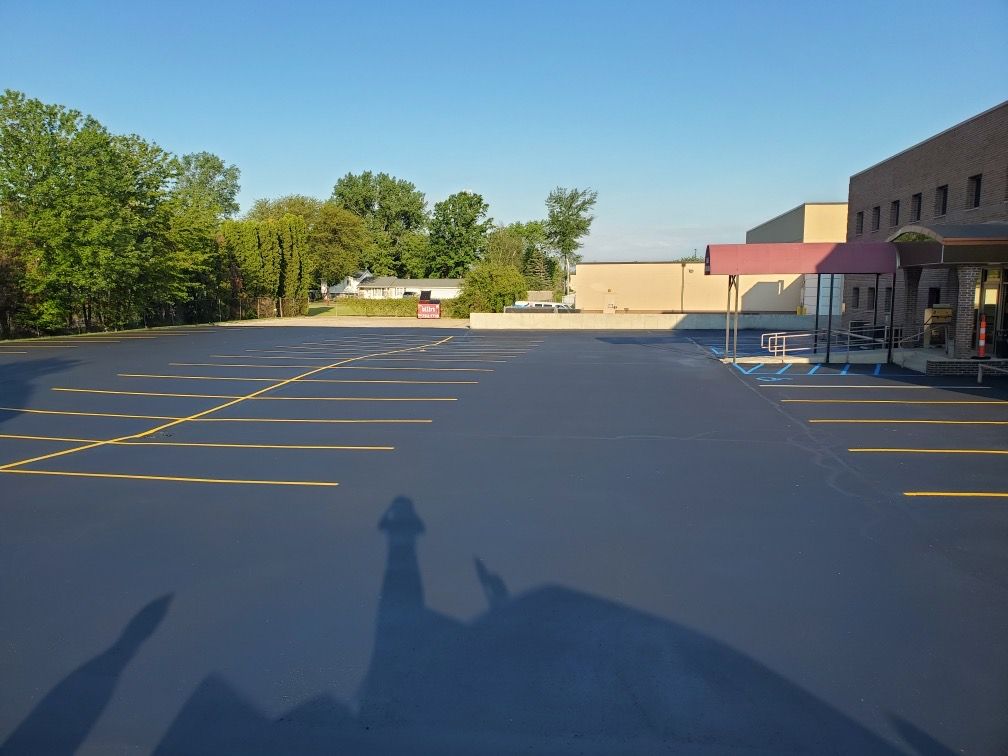 A large parking lot with a building in the background