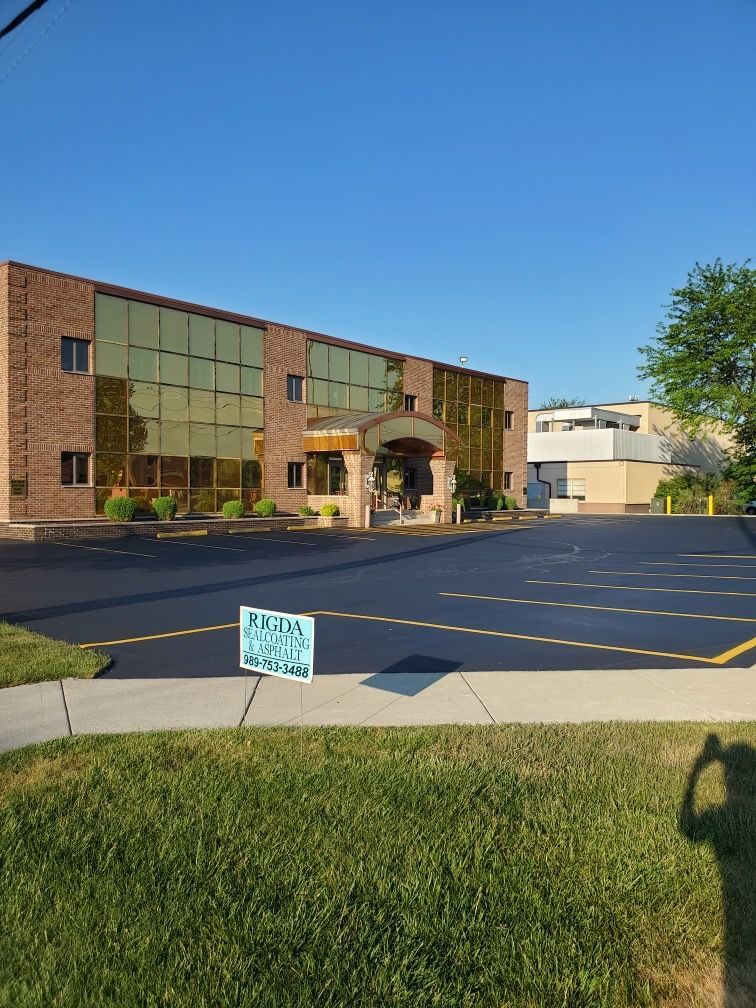 A large brick building with a parking lot in front of it.