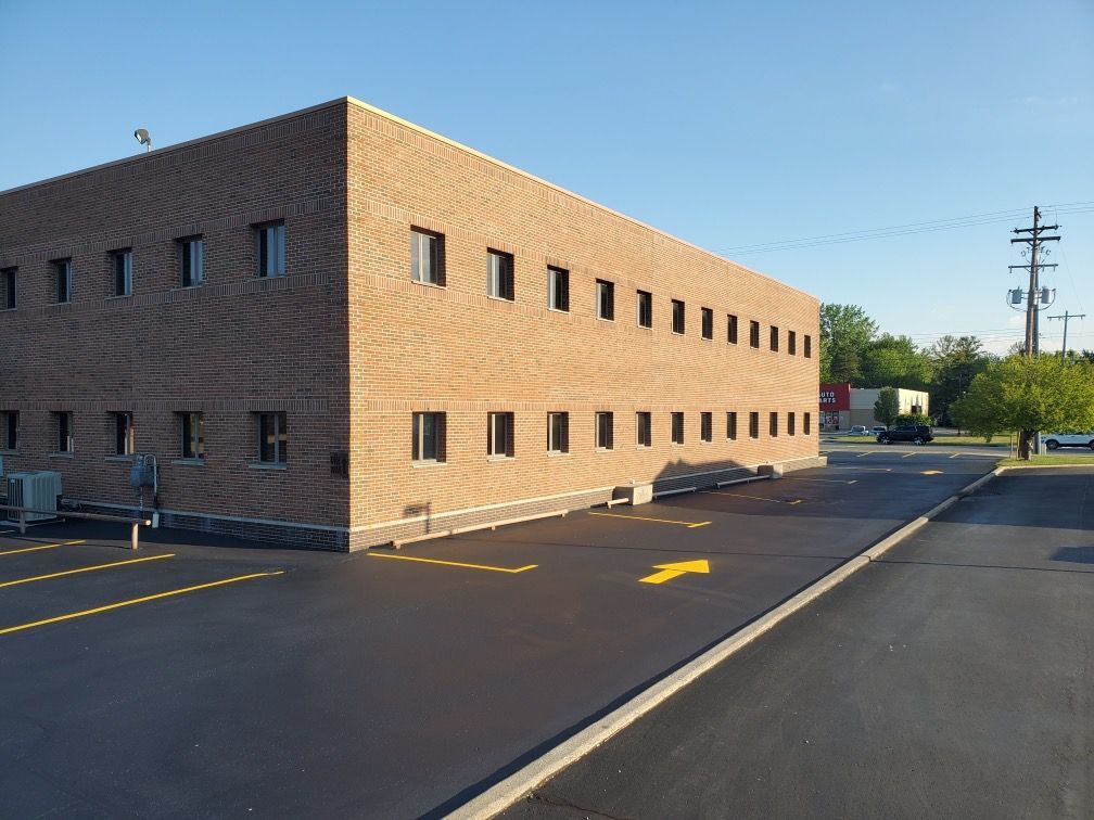 A large brick building with a parking lot in front of it
