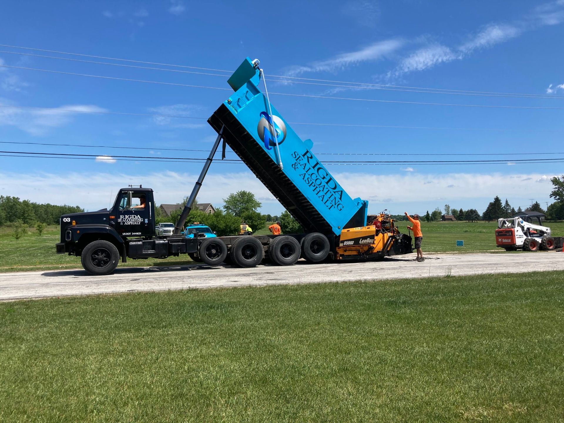 A dump truck is sitting on the side of a road.