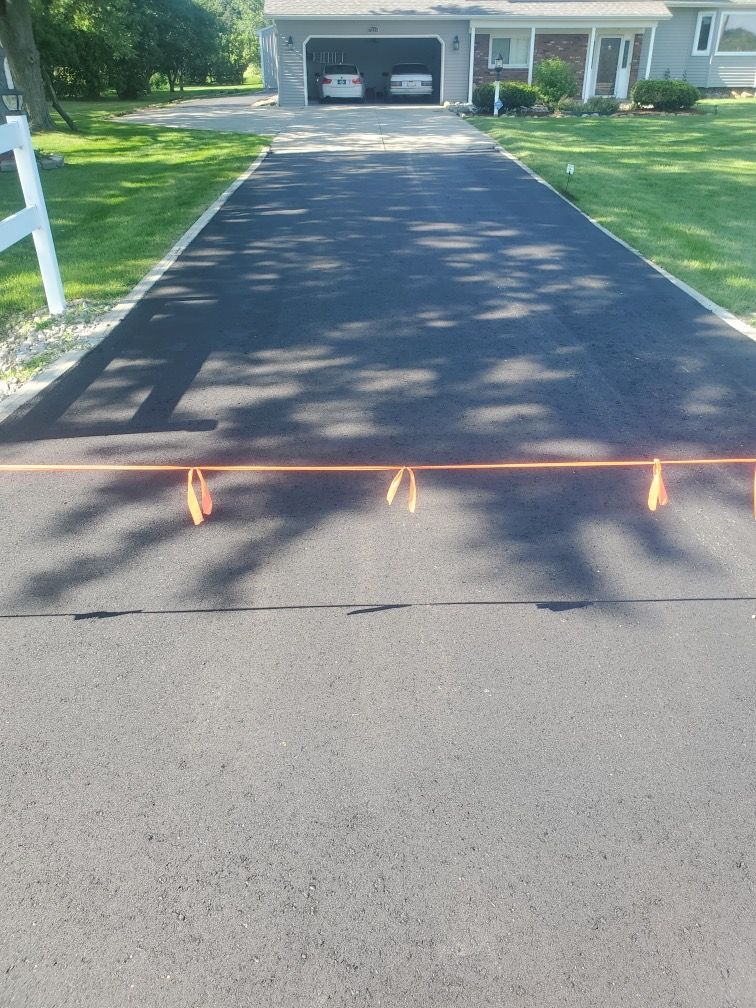 A driveway leading to a house with two cars parked in the garage