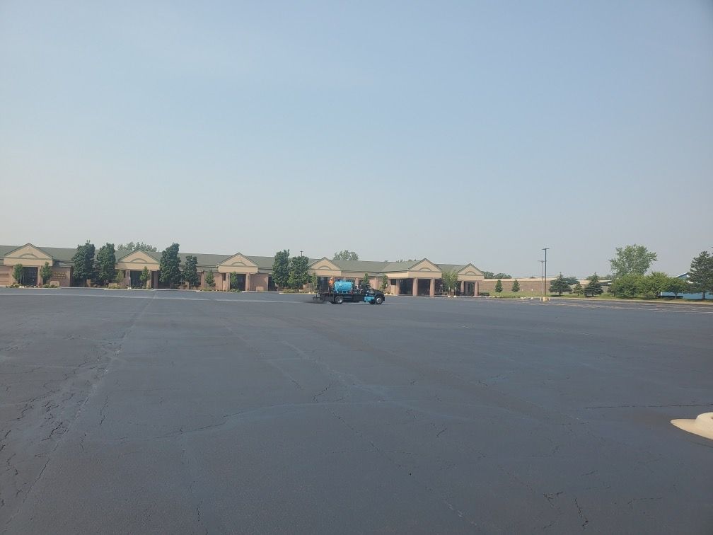 A large empty parking lot with a building in the background.