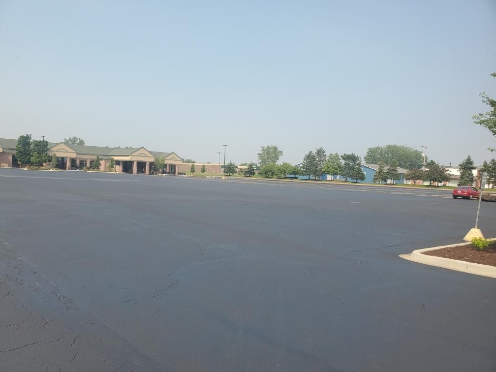 An empty parking lot with a building in the background.