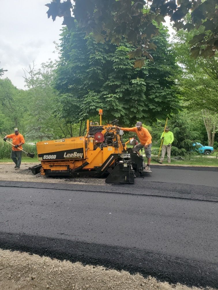 A group of construction workers are working on a road.