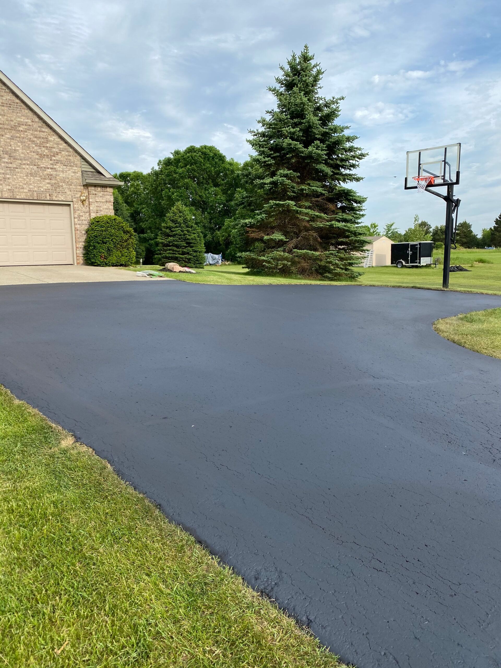 There is a basketball hoop in the middle of the driveway.