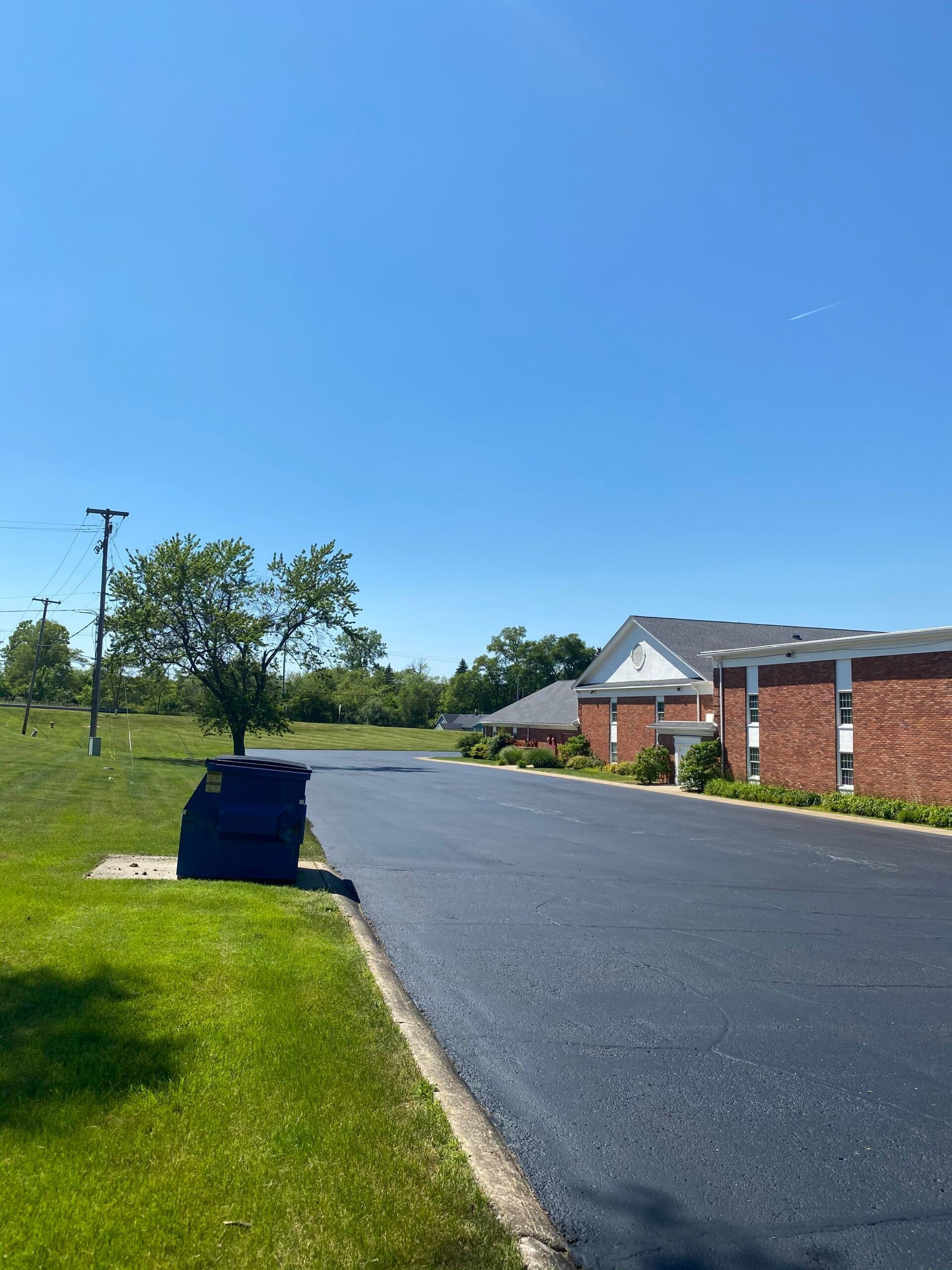 A road with a brick building on the side of it.