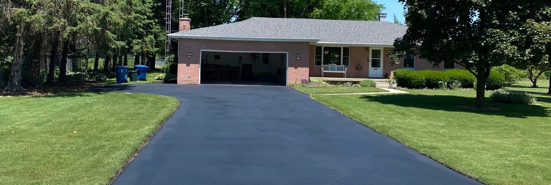 A brick house with a driveway leading to it and a garage.