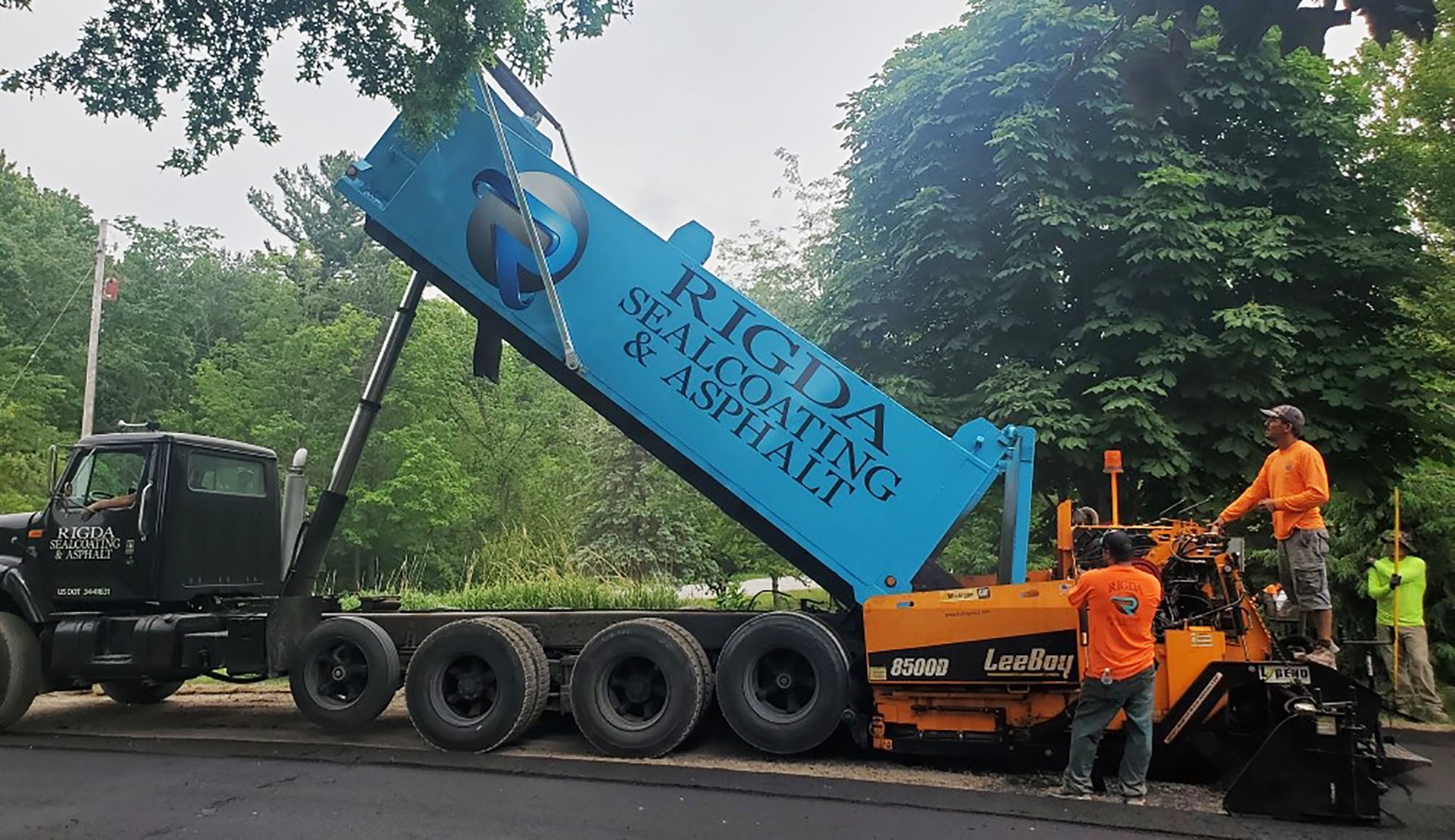 A rigida sealcoating and asphalt truck is being loaded with asphalt