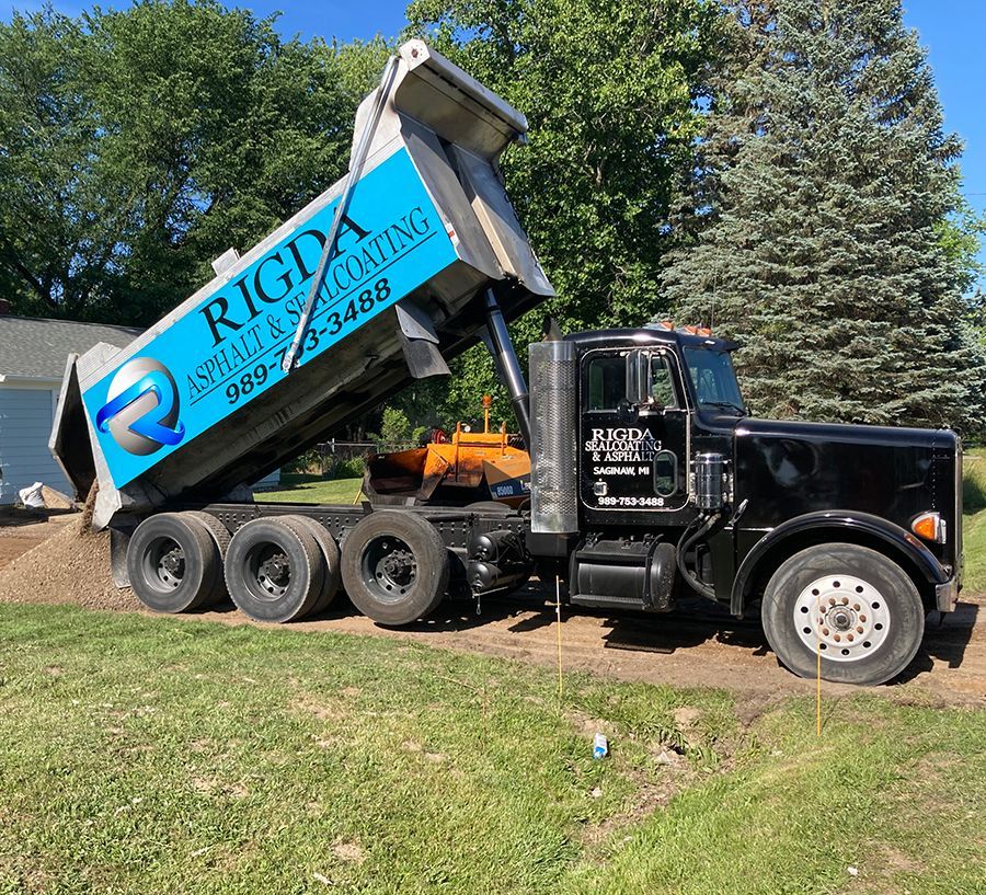 A dump truck is sitting on top of a lush green field.