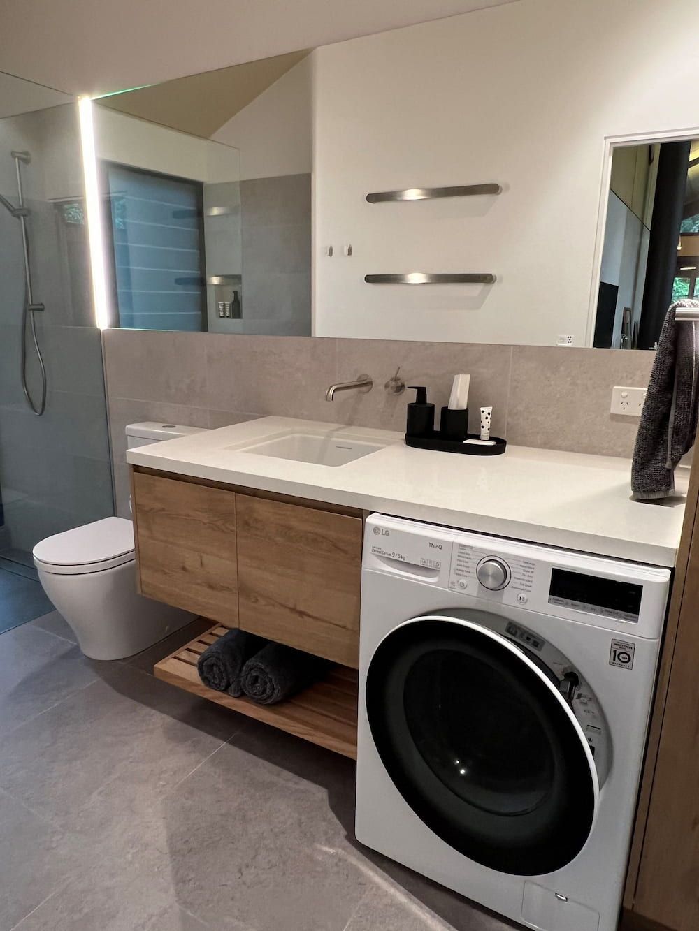 A Bathroom With A Washing Machine, Sink, Toilet And Mirror — Cross Cabinets In Chevallum, QLD